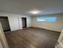Bright and modern bedroom featuring sleek flooring, ample closet space, and a large window for natural light.