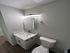 Sleek modern bathroom with stylish vanity, wall-mounted lighting, and elegant fixtures on hardwood flooring.