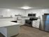 Modern kitchen with sleek white cabinetry, stainless steel appliances, and elegant countertop design.