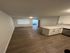 Modern open-plan living area with sleek hardwood floors and a stylish kitchen, perfect for entertaining.