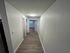 Bright, inviting hallway with sleek hardwood flooring and modern lighting in a contemporary apartment.