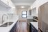Modern kitchen with sleek stainless steel appliances, elegant white cabinets, and luxurious gold fixtures, offering a bright and inviting culinary space.