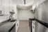 Modern kitchen with sleek stainless steel appliances, white cabinetry, and a skylight for natural lighting.