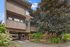 Charming apartment building with curved balconies and lush greenery, offering a serene urban living experience.