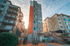Modern apartment complex with colorful exterior and welcoming entrance, surrounded by lush greenery.