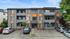 Modern apartment building with vibrant orange accents, featuring spacious balconies and convenient parking spaces.