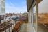 Charming urban balcony view with nearby shops and vibrant city streets below, offering a perfect blend of relaxation and convenience.