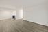 Bright open-concept living space with modern wood flooring and a sleek kitchen nook, perfect for stylish urban living.