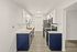 Modern kitchen with sleek white cabinets, stainless steel appliances, and elegant dark blue lower cabinetry.