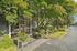 Inviting apartment entrance surrounded by lush greenery and vibrant trees, offering a serene and welcoming atmosphere.