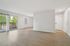 Bright, airy living room with modern flooring and large windows opening to a serene balcony view.