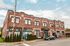Charming brick apartment building with classic architecture, featuring large windows and a cozy, inviting entrance.