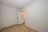 Bright and inviting room with elegant wooden flooring and a door leading to a modern bathroom.