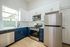 Modern kitchen with sleek stainless steel appliances, elegant two-tone cabinetry, and bright natural light.