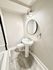 Elegant bathroom with modern fixtures, round mirror, and stylish subway tiles, exuding sophistication and contemporary charm.