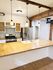 Modern kitchen with elegant pendant lighting, stainless steel appliances, and a spacious wooden countertop, perfect for culinary enthusiasts.