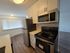 Modern kitchen featuring sleek stainless steel appliances, stylish subway tile backsplash, and elegant wood flooring.