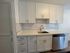 Modern kitchen with sleek white cabinets, subway tile backsplash, and stainless steel appliances, perfect for culinary enthusiasts.