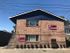 Charming brick apartment building with Nordic-inspired design, featuring vibrant flags and inviting entryway.
