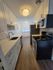 Modern kitchen with sleek white cabinetry, stainless steel appliances, and elegant wood flooring.