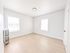 Bright, open bedroom with large windows and elegant hardwood floors, perfect for a serene living space.