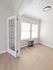 Bright, modern apartment corner with chic glass-paneled door, elegant light fixture, and pristine wood floors.