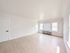 Bright and spacious empty room with light wood flooring, large windows, and a clean, modern design.