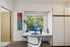 Bright and modern home office with a large window view, sleek desk setup, and artistic wall decor.