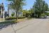 Charming residential street with a cozy house surrounded by lush greenery, perfect for serene living.