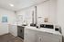 Modern laundry room featuring high-efficiency washers and dryers with a convenient utility sink and bright natural light.