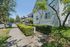 Charming street view of a well-maintained apartment building with lush greenery and a sunny sidewalk, offering a welcoming neighborhood vibe.