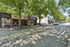 Charming urban street scene with local businesses, lush green trees, and a welcoming atmosphere, ideal for city living.