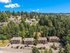 Charming hillside apartments surrounded by lush green forest, offering serene living with convenient access to nearby homes.