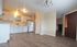 Bright open kitchen with white cabinets, modern appliances, and elegant wood flooring, perfect for culinary creativity.