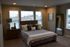 Luxurious bedroom with elegant decor, featuring a plush bed, stylish bedside table, and large windows for natural light.