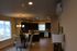 Inviting open-concept kitchen and dining area featuring sleek dark cabinets, elegant lighting, and a cozy dining table arrangement, perfect for hosting and entertaining.
