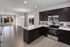 Modern open-concept kitchen and living area with sleek hardwood floors, elegant dark cabinetry, and large windows inviting ample natural light.