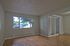 Bright living area with large window, sleek hardwood floors, and sliding glass doors for abundant natural light and modern appeal.