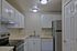 Modern kitchen with sleek stainless steel refrigerator, elegant white cabinetry, and ample countertop space for culinary creativity.
