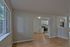 Inviting open-plan apartment with natural light, featuring sleek hardwood floors and a modern kitchen view.