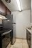 Modern kitchen with elegant dark wood cabinetry, sleek stainless steel appliances, and bright overhead lighting.