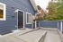 Charming exterior of a modern home with a sleek blue facade and inviting entryway, surrounded by lush greenery.