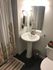 Charming bathroom featuring a sleek pedestal sink, modern fixtures, and a stylish cactus-themed shower curtain.