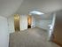 Charming attic space with plush carpeting, skylight, and adjacent bathroom and closet, ideal for cozy living.