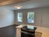 Bright and airy open-concept living area with large windows and modern kitchen in a contemporary apartment.