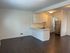 Bright and modern kitchen featuring sleek stainless-steel appliances, elegant white cabinetry, and rich dark wood flooring.