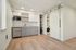 Modern apartment kitchen with sleek cabinetry, integrated appliances, and stylish wood flooring offering a chic and efficient space.