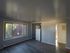 Spacious living room with large window inviting natural light and scenic views, featuring sleek hardwood floors and a modern open layout.