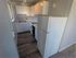 Charming compact kitchen with modern appliances and sleek cabinetry, featuring bright lighting and stylish flooring.