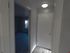Bright hallway with elegant flooring leading to a spacious room, accentuated by modern door design and natural light.